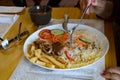 A lady having lunch at the restaurant with rice, farofa, beef steak with onions, grilled on a plate, french fries and a tomato, Royalty Free Stock Photo