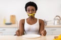 Lady Having Tied Mouth With Measuring Tape Sitting In Kitchen