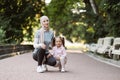 Lady in hijab, sitting together with her cute daughter, ready to do physical activity in the park Royalty Free Stock Photo