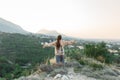 Lady hiker with backpack standing on top of the mountain and enjoying valley view.Travel alone concept. traveling in new reality Royalty Free Stock Photo