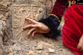 Lady in historic dress beside heraldic sign carved in stone.