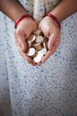 A lady holding coins in a gesture of giving or showing it