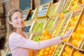 Lady holding oranges in greengrocers