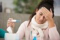 lady holding thermometre and feeling temperature forehead Royalty Free Stock Photo