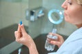 Lady holds pill and bottle of water in her hands Royalty Free Stock Photo