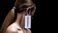 Lady with housewife label on ear against dark background, place of women, sexism