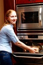 Lady infront of a open oven Royalty Free Stock Photo