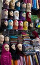 A lady inspects the variety of colourful headscarves for sale in the Fez medina, Morocco.