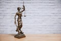 Lady Justice or Justitia the goddess of justice statue on desk - legal law legislation concept