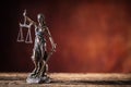 Lady Justicia holding sword and scale bronze figurine on wooden