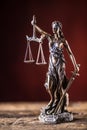 Lady Justicia holding sword and scale bronze figurine on wooden Royalty Free Stock Photo