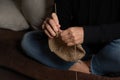 lady knitting with a needle, sitting on a armchair