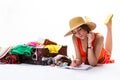 Lady lays near overfilled suitcase.