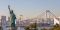 Lady liberty juxtaposed against Rainbow Bridge in Tokyo, Japan Royalty Free Stock Photo