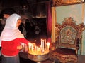 Lady lighting candle in Church of the Holy Sepulchre, Jerusalem