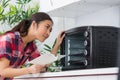 Lady looking at countertop oven holding instructions