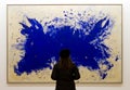 Lady looking at a piece by Yves Klein in the art gallery