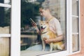 Lady listening to music with wireless earphones using smartphone stroking dog Royalty Free Stock Photo