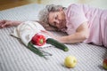 Lady lying on the floor next to shopping bag with vegetables