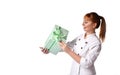 Lady in medical uniform smiling, holding green gift box tied with ribbon. Posing isolated on white. Sales, advertising. Close up