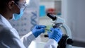 Lady microbiologist preparing herbal sample for examination, laboratory work