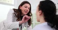 Lady otolaryngologist checks condition of patient throat