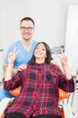 Lady patient and hygienist being happy showing peace