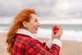 Lady in plaid shirt holding a gift in his hands enjoys beach. Coastal area. Christmas, New Year holidays concep