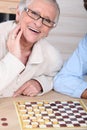 Lady playing checkers with somebody.