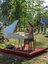 Lady playing white piano, village charity event