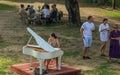 Lady playing white piano, village charity event