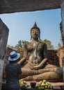 Lady pray sitting Buddha statue in the Ancient temple Thailand Royalty Free Stock Photo