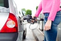 Lady pumping gasoline fuel in car at gas station. Royalty Free Stock Photo