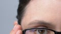 Lady putting on glasses to see clearly, problems with vision, nearsightedness