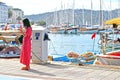 A lady in a red dress checking her phone by the Turkish Harbour