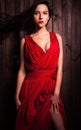 Lady in red pose on wooden background. Royalty Free Stock Photo