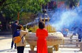 Lady in red praying with incense sticks