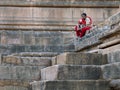 Lady rest on stone steps of Kunda, the reservoir of sun temple Modhera Royalty Free Stock Photo