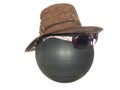 Lady`s brown hat with a black lace and a button and dark goggles on a black plastic ball isolated on a white background