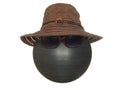 Lady`s brown hat with a black lace and a button and dark goggles on a black plastic ball isolated on a white background