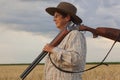 The lady`s farmer with a hat keeps her shootgun in her hand Royalty Free Stock Photo