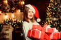 Lady santa celebrate christmas at home. Woman santa claus hat on christmas eve. Girl stylish makeup red lips hold many
