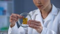 Lady scientist examining cheese sample in petri dish, poor quality food check