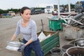 Lady in scrap yard by car door Royalty Free Stock Photo