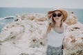 Lady at the sea. Attractive young woman on background of sea. Barefoot girl walking along the rocky beach Royalty Free Stock Photo