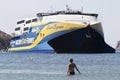 Lady on the sea in front of a passenger ferryboat