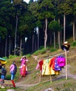 Lady selecting Kimono from colourful collection in a traditional nepalese and bhutanese dress rental shop in India