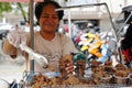 A lady sells deep fried pork liver in her street food cart