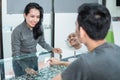 a lady shop clerk shows a pair of glasses in a window to a customer