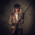 Lady with shotgun and hat from wild west on dark background. Royalty Free Stock Photo